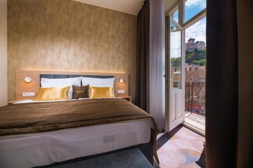 ein Schlafzimmer mit einem Bett und einem großen Fenster in der Unterkunft BELROS Hotel in Trenčín