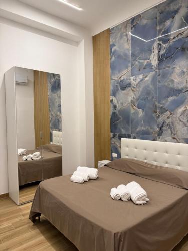 a bedroom with two towels on a bed with a mirror at Largo Sicilia B&B in Avola