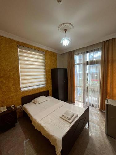 a bedroom with a bed and a large window at Nelly Hotel in Batumi