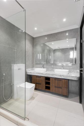 a bathroom with two sinks and a toilet and a shower at Metro Apartments in Lagos