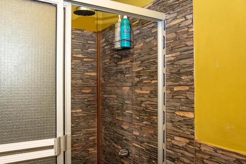 a shower with a blue bottle on the wall at Cozy Cabin in Cumbres del Nacimiento, La Unión Sur in Conchagua