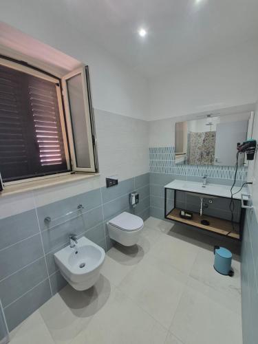 a bathroom with a sink and a toilet and a tub at Terra e Cielo Rooms in Parghelia