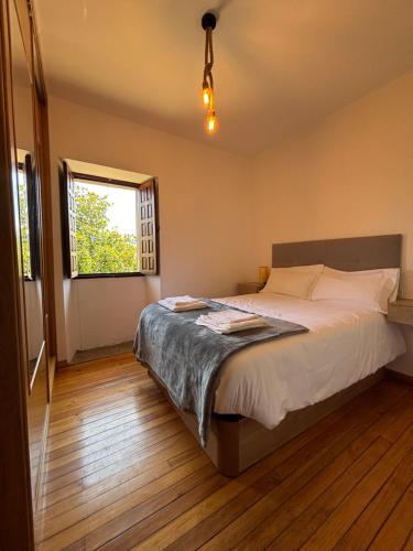 a bedroom with a large bed with a window at Chalet do Médico in Rodeiro