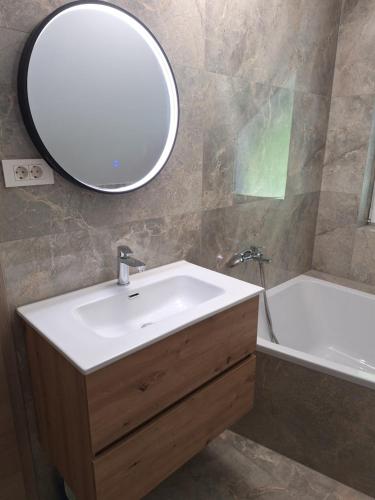 a bathroom with a sink and a mirror and a tub at App TI-SA in Laze v Tuhinju
