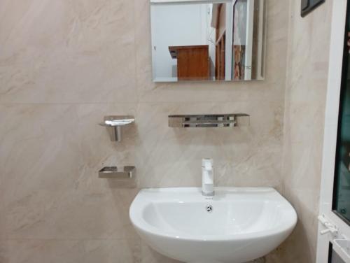 a bathroom with a white sink and a mirror at East HOME Kalmunai in Kalmunai