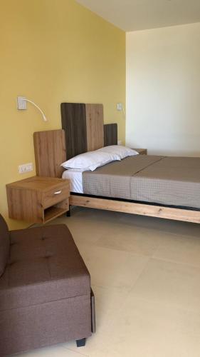 a bedroom with a bed and a ottoman in a room at Terra e Cielo Rooms in Parghelia