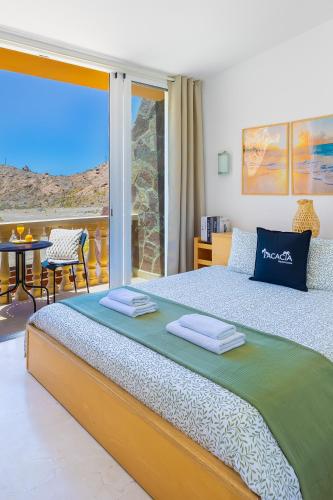 a bedroom with a large bed and a balcony at Casa Ocean Love Sea View Duplex Tauro Golf in Mogán