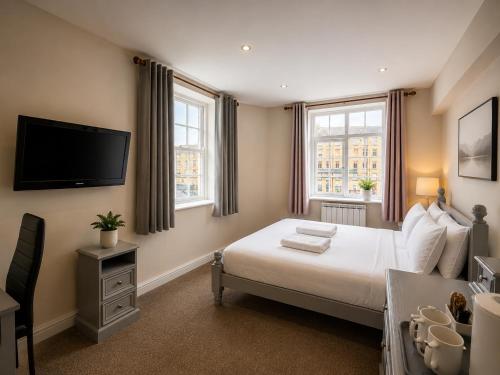 a bedroom with a bed and a flat screen tv at Wool Merchant Hotel HALIFAX in Halifax