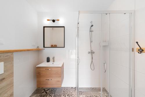 a bathroom with a shower and a sink and a mirror at Domki Nad Morzem Babki z Piasku Dziwnów in Dziwnów