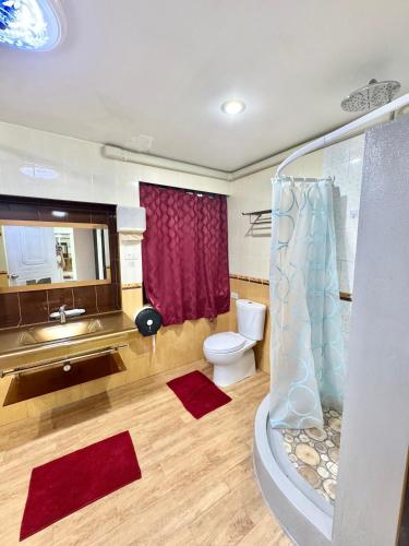 a bathroom with a shower and a toilet and a sink at Baan Kalaya Homestay in Nonthaburi