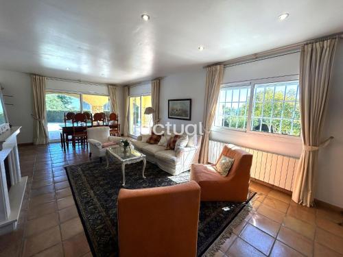 a living room with a couch and chairs and windows at Casa Torrebosca 43 in Platja d'Aro