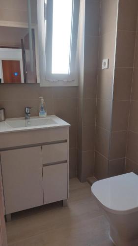 a bathroom with a sink and a toilet and a mirror at Costadaurada2000 Sunset Beach Cunit in Cunit