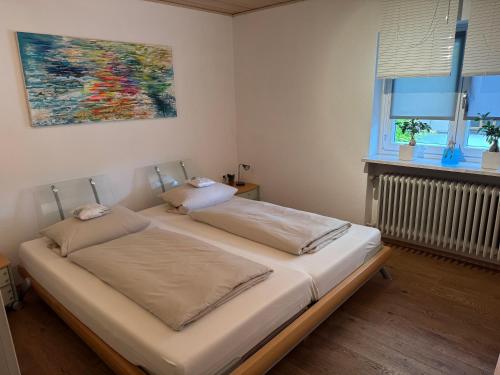 a bedroom with two beds and a painting on the wall at Ferienwohnung im Grünen in Gößweinstein