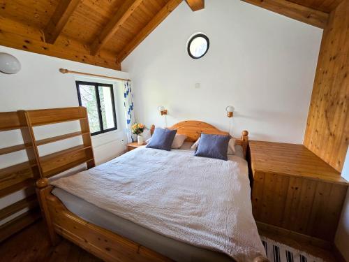 a bedroom with a wooden bed with a clock on the wall at Rustico Marietta by HolAp SA in Brissago