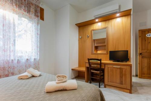 a bedroom with two beds and a desk with a television at Agriturismo EUCALIPTO in Perdifumo