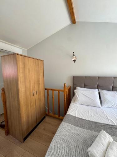 a bedroom with a bed and a wooden cabinet at Tiny Diamond in Plomari