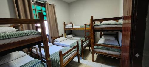 a room with a bunch of bunk beds at Chácara Umbelina Hospedaria in Cachoeira Paulista