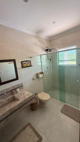 a bathroom with a shower and a toilet and a sink at Pousada & Hostel América in Barreirinhas