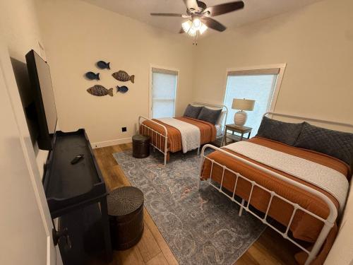 a bedroom with two beds and a flat screen tv at Lakefront Villa with Dock Swim Platform in Lake Ozark