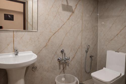 a bathroom with a toilet and a sink and a shower at Guest House Suites in Bangalore