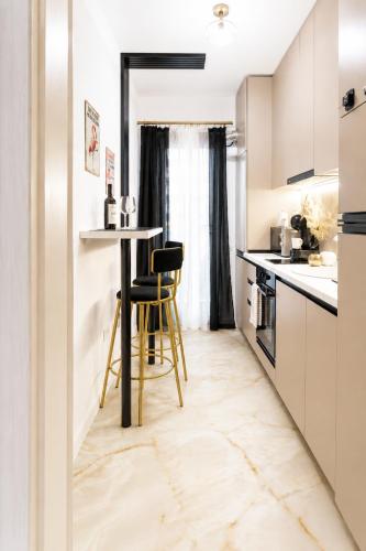 a kitchen with a table and two stools at OCCO by the Jacuzzi in Popeşti-Leordeni