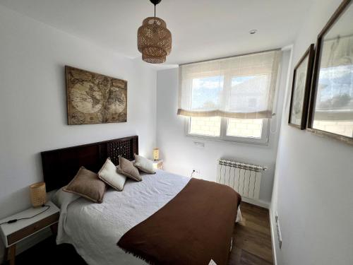 a bedroom with a bed with pillows on it at El Cubo in La Lastrilla