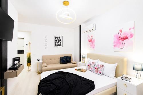 a bedroom with a large bed and a couch at OCCO by the Jacuzzi in Popeşti-Leordeni