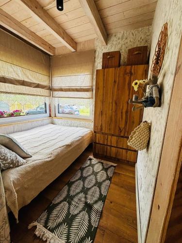 a small room with a bed and a window at Chatka u Radka in Szczodrowo
