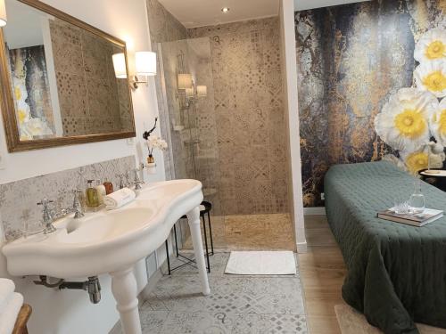 a bathroom with a sink and a shower and a bed at La Bastide des Mûriers in Deaux