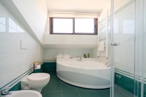 ein Badezimmer mit Badewanne, Toilette und Waschbecken in der Unterkunft SIGIS HOTEL - Fiumicino in Fiumicino