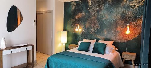 a bedroom with a bed with a painting on the wall at Le murmure des pins in Villemoustaussou
