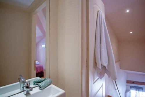 a bathroom with a sink and a towel hanging on a wall at Guilford Loft in Corfu
