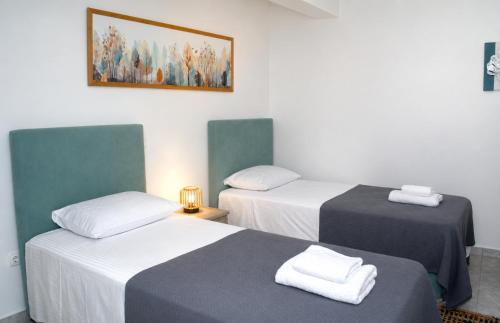 a room with two beds and a painting on the wall at Thalassia Pefkias Apartment in Xylokastro
