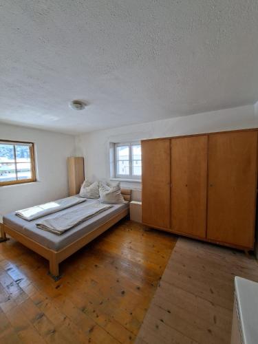 a bedroom with a bed and a large wooden cabinet at Gästehaus Hammerle Holzgau in Holzgau