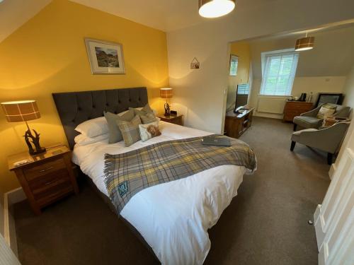 a bedroom with a large bed with a cat laying on it at Craigbank Guest House in Crianlarich