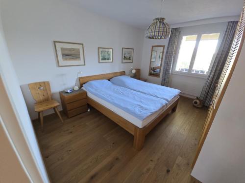 a bedroom with a bed and a chair and a mirror at Bella Val (206 Se) in Lenzerheide
