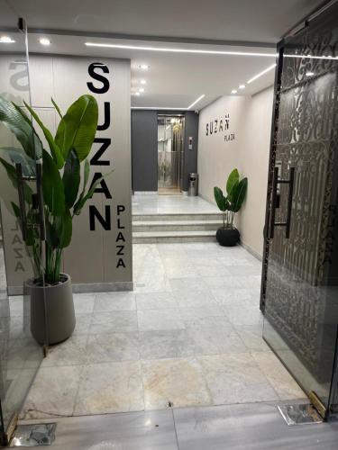 a lobby with a door and a potted plant at Suzan Hotel Apartments in Amman