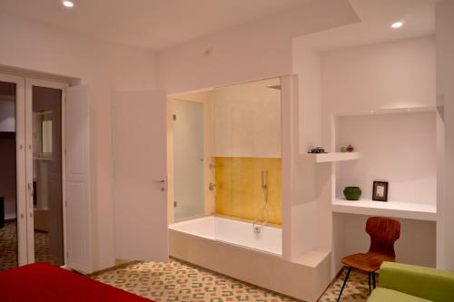 bagno con vasca e sedia in camera di Limen Matera Guesthouse a Matera