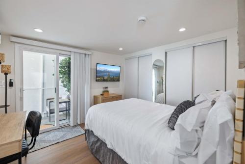 a bedroom with a large bed and a sliding glass door at Newly Renovated 1BR Suite, Patio BBQ, Fire Pit in Simi Valley