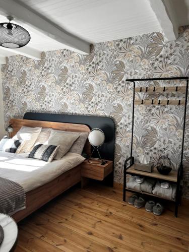 a bedroom with a bed and a wall at Le vieux colombier in Le Monastier sur Gazeille