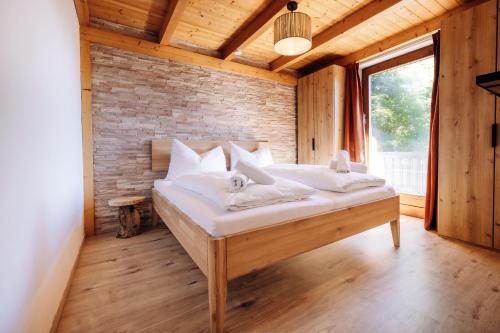 a bed in a room with a brick wall at Stoderglück by Alpenidyll Apartments in Gröbming