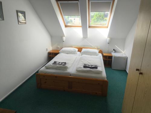 a small bedroom with two beds in a attic at Penzion-BelBar Zlín in Zlín