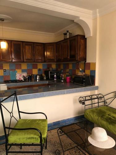 a kitchen with a counter and a chair and a table at Moana Guest House in Tamraght Ouzdar