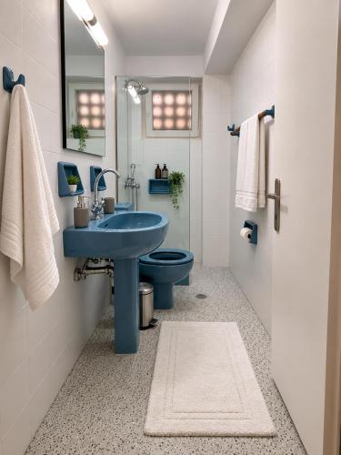 a bathroom with a blue sink and a toilet at Ancora Beach House by "elite" in Tsilivi