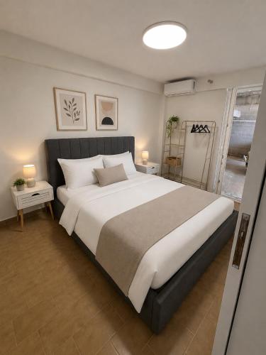 a bedroom with a large white bed with two tables at Ancora Beach House by "elite" in Tsilivi