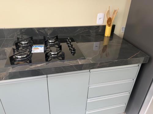 a counter with three burners on top of a counter at Apartamento Espaço e Conforto Cerejeiras in Várzea Grande