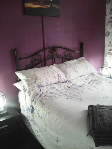 a bedroom with a white bed with purple walls at yeolde 2 bedroom Seashak Detached Cottage LOW 2026 PRICES NEWLY REFURBISHED PLUS FREE ALL ELECTRIC ENJOY in Bridlington