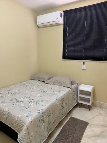 a bedroom with a bed and a air conditioner at Apartamento Espaço e Conforto Cerejeiras in Várzea Grande