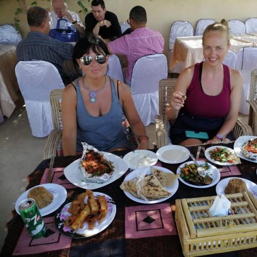 two women sitting at a table with plates of food at Safarova Tours in Fayoum