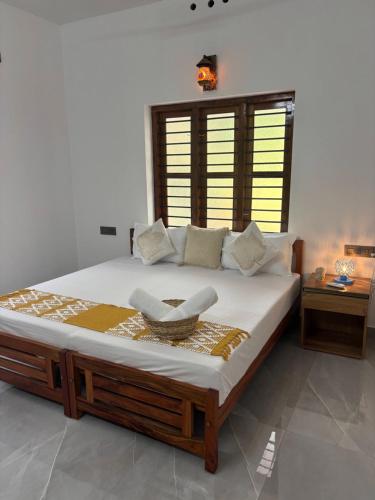 a bedroom with a large bed with a basket on it at Villa Lemon in Varkala